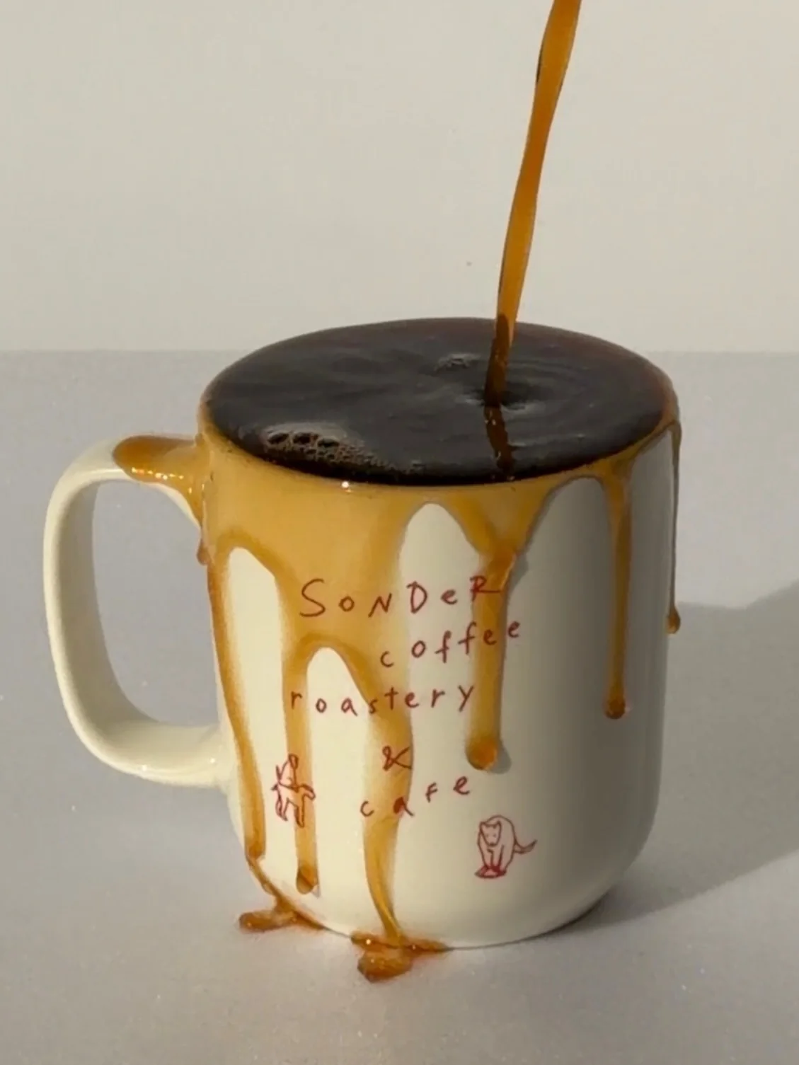 Coffee pouring over a caramel-topped Sonder cup