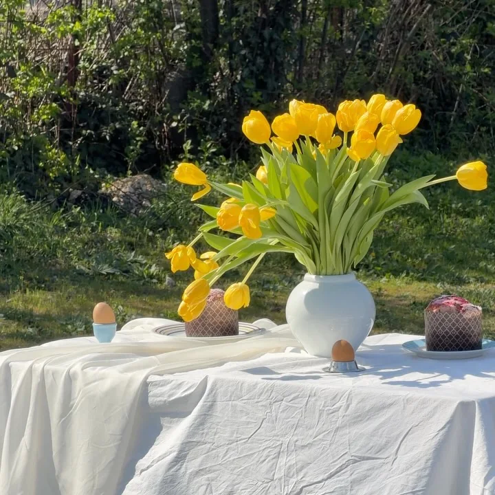 Yellow tulips and Easter bread on a white table